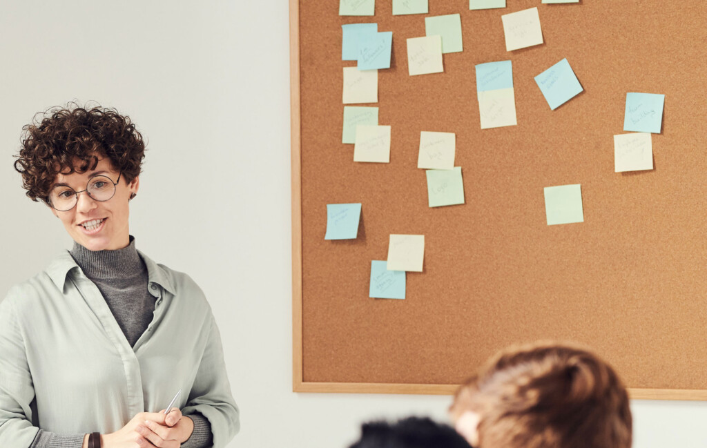 Frau steht vor Korkwand als Powerpoint Alternative