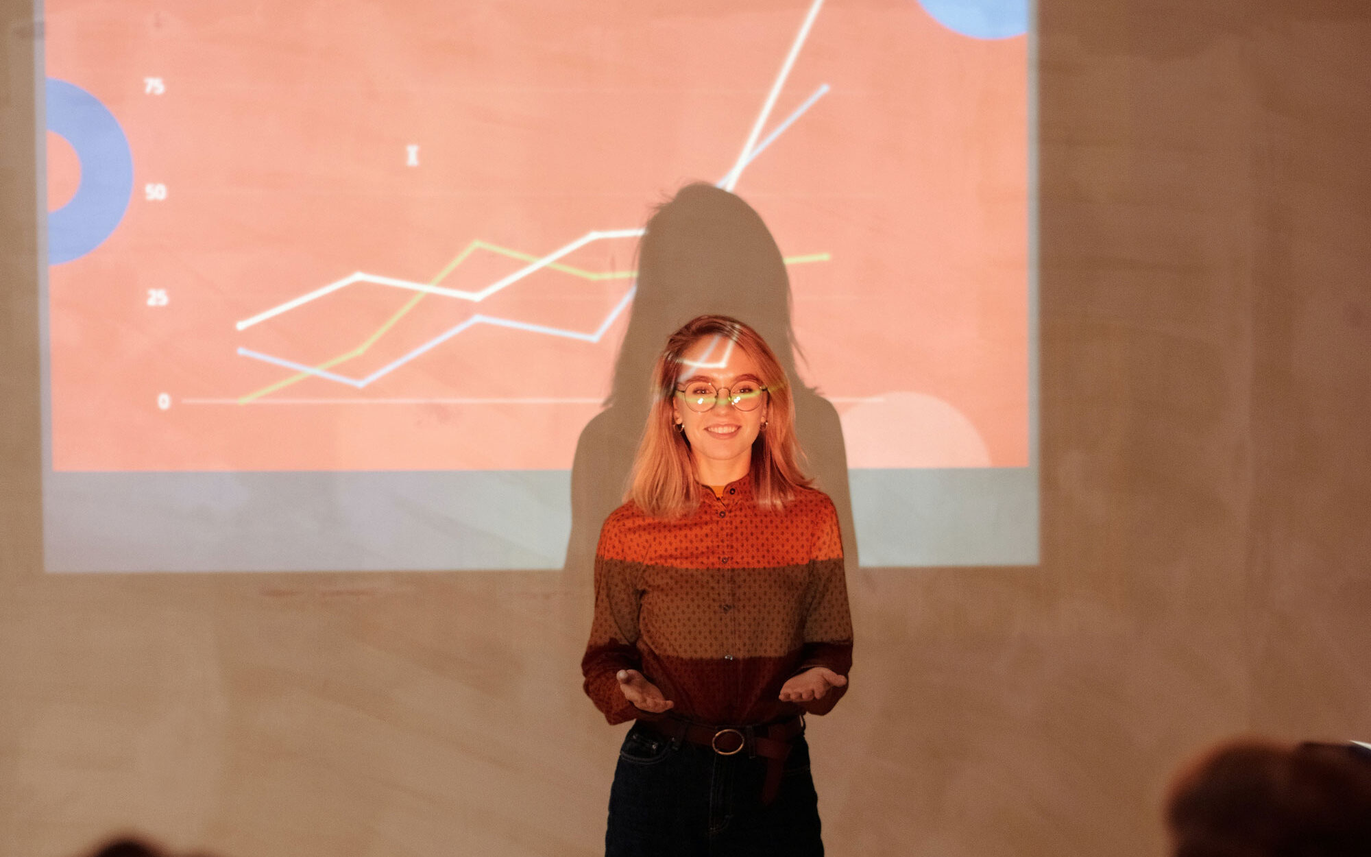 Frau zeigt Powerpoint und steht im Beamerlicht