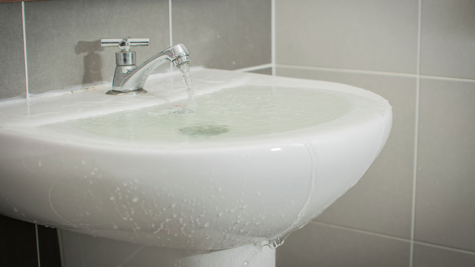 Weisses überlaufendes Waschbecken